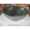 Lavandino in marmo verde a forma rotonda con lavabo in pietra grezza